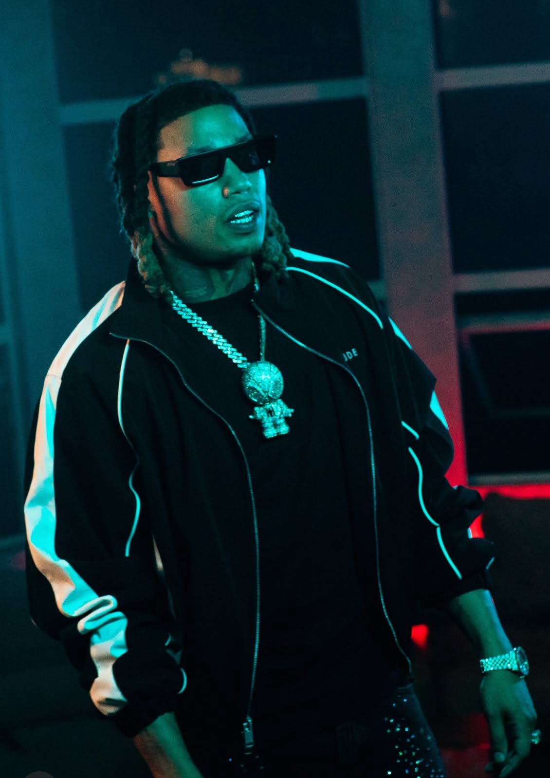 Artist in sunglasses under teal lighting